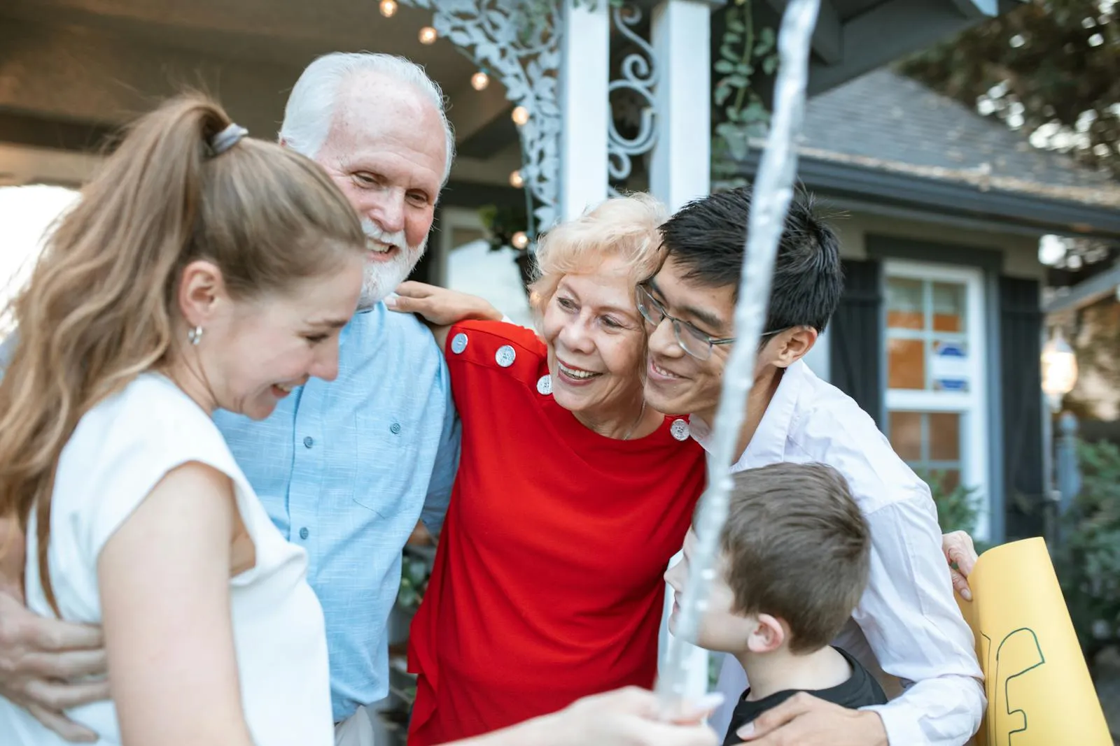 A happy multigenerational family embracing outside their home